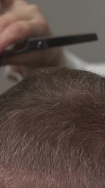 Taraklı ve makasla beyaz erkeğe yakın çekim, stilist makas kaplama, taçı yeniliyor ve karışıyor. Medya