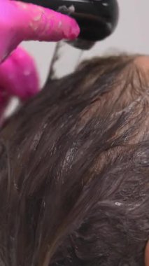 Kafkasyalı müşteri son durulama ve kafa derisi masajı alıyor stilist sabit su akıntısı ve parmak ucu kullanıyor. Medya