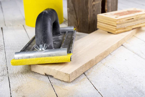 stock image Sanding wood with sandpaper. Carpentry accessories for precise woodworking. Light background.