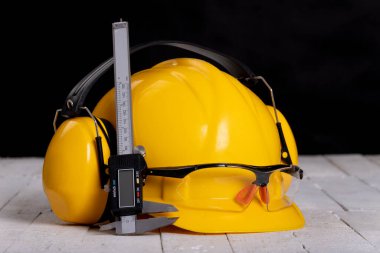 Tezgahın üzerinde bir kask ve koruyucu gözlük. Ev atölyesinde çalışmak için. Koyu arkaplan.