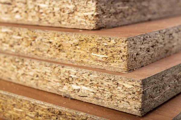 Ev mobilyalarının inşası için parçacık tahtası. Marangozhanedeki malzeme yığını. Hafif arkaplan.
