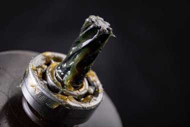 Yağ tabakası kayganlaştırıcı ve elektrik pervanesinin iğnesi. Motor parçalarının servis işi. Koyu arkaplan.