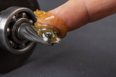 Yağ tabakası kayganlaştırıcı ve elektrik pervanesinin iğnesi. Motor parçalarının servis işi. Koyu arkaplan.