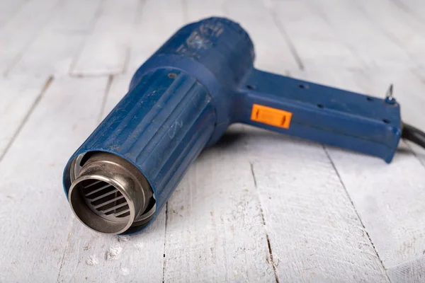 Heat gun for removing old paint. Accessories for small work in the workshop. Dark background.