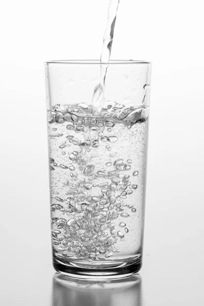 Wlewanie Wody Gazowanej Szklanki Pojemnik Przechowywania Płynów Lekkie Tło — Zdjęcie stockowe
