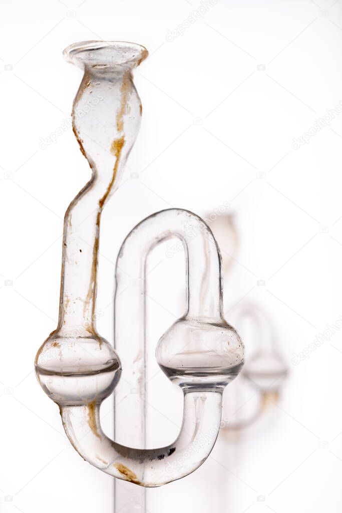 Old dirty fermentation tube. Glass accessories for wine fermentation. Light background.