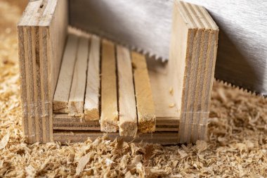 Marangozhanede küçük bir odun parçasını testereyle kesmek. Ev atölyesinde hafif marangozluk işi..