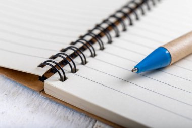 Temiz, boş bir defter ve bir kalem. Notlarını yazabileceğin bir yer. Hafif arkaplan.