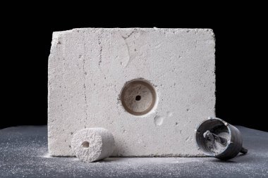 Tuğlada büyük çaplı delikler açmak. Elektrik kutuları monte etmek için delikler. Koyu arkaplan.