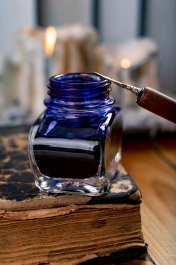 Eski kitapların arka planına mürekkep ve kalem yazıyorum. Şairin işyeri. Koyu arkaplan.