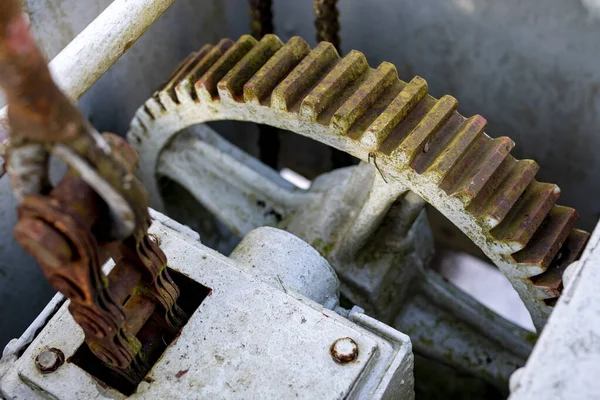 Large gears in an old gearbox. Steel structure to transfer rotational energy. Light background.