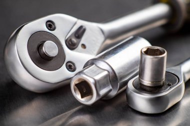 Tezgahta krom cırcır anahtarı var. Mekanik onarım için kullanılan aletler. Atölye çalışma yeri.