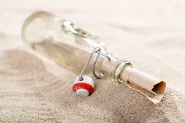 Deniz kumu üzerinde cam bir şişede mektup. Mesaj yazıldı ve uzak geçmişte gönderildi. Sahilde değerli bir buluş. Yaz mevsimi.