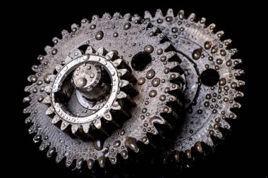 Tekerleklere su damlıyor. İçten yanmalı motor için ıslak yedek parçalar. Koyu arkaplan