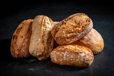 Siyah mutfak masasında taze ekmek. Ekmek servis için hazır. Koyu arkaplan.