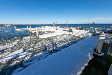 Mechelinki, Pomorskie Polonya - 14 Şubat 2021: Baltık Denizi kıyısında donmuş rıhtım. Bir balıkçı limanının altyapısını kaplayan buz. Kış mevsimi.