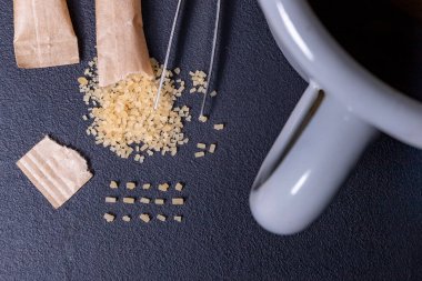 Baston şekerli çay. Masada şeker taneleri var. Koyu arkaplan.