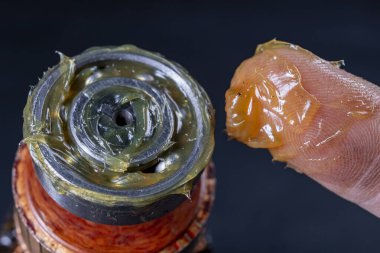 Yağ ile bilyeli yağlama. Kurul bir mekanik atölyede çalışıyor. Koyu arkaplan.