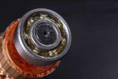 Bilye yağ ile yağlanmış. Kurul bir mekanik atölyede çalışıyor. Koyu arkaplan.