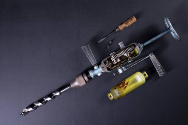 Kapağı eski bir matkapla vites kutusundan çıkarılmış. Marangozluk atölyesinde çalışmak için araç gereç bakımı. Koyu arkaplan.