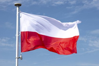Bulutlu gökyüzünün arka planında Polonya bayrağı. Direkte Polonya 'nın ulusal sembolü. Yaz mevsimi.