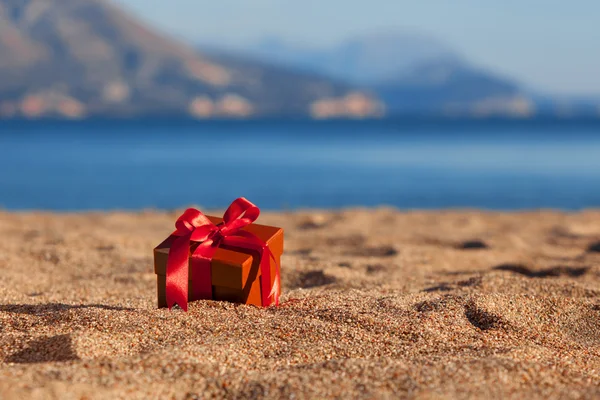 Scatola regalo colore terracotta ona spiaggia — Foto Stock