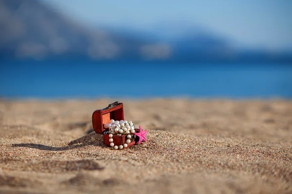 Pecho decorativo con joyas y estrellas de mar en una playa —  Fotos de Stock