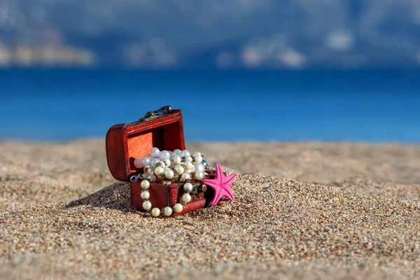 Pecho decorativo con joyas y estrellas de mar en una playa —  Fotos de Stock