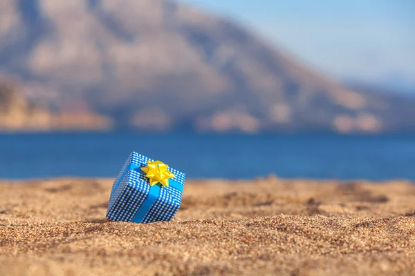 Blauwe giftdoos op een strand — Stockfoto