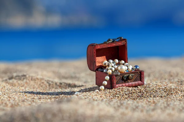 Comò decorativo con gioielli su una spiaggia — Foto Stock