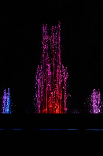 Line of multicolored spitting and dancing fountains with sharp splashes