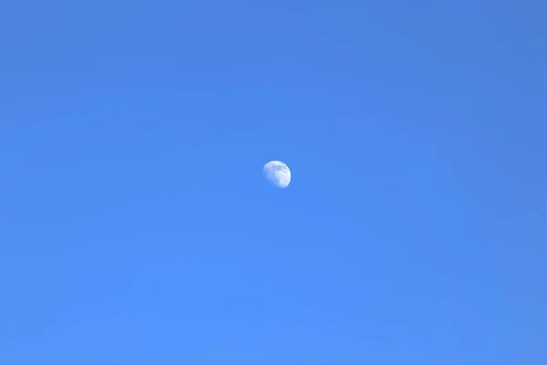 Moon in the blue sky during the day