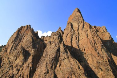 Dağların kayaları mavi gökyüzüne karşı. İç mekan için uygun, duvar kağıtları, fotoğraf çerçeveleri ve dağ manzarası aşıkları.