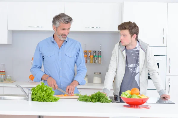 Padre e hijo en la cocina, preparando verduras — Foto de Stock