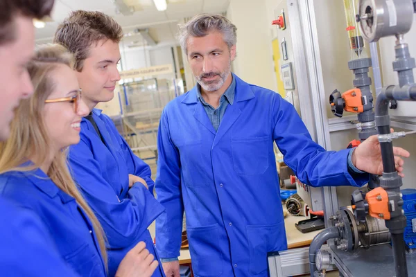 Lehrer erklärt Lehrlingen Maschinen — Stockfoto