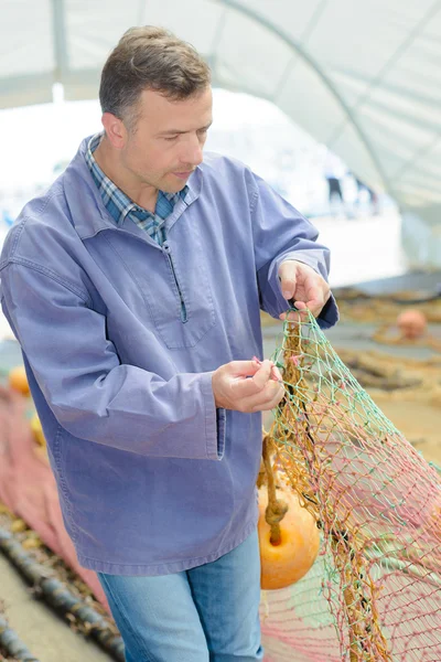 Pescatore che tiene rete e pescatore — Foto Stock