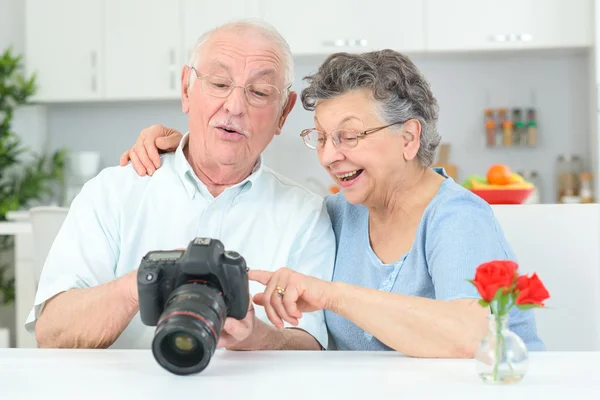 Starsze pary patrząc na fotografie odwrocie aparat cyfrowy — Zdjęcie stockowe