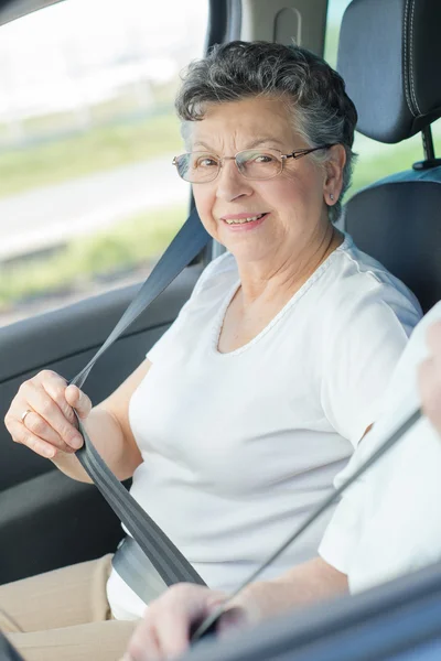 Äldre dam att sätta på hennes säkerhetsbältet — Stockfoto