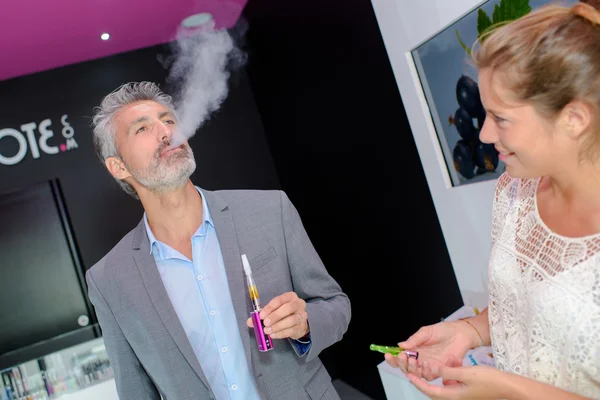 Hombre probando un cigarrillo electrónico, exhalando vapor —  Fotos de Stock