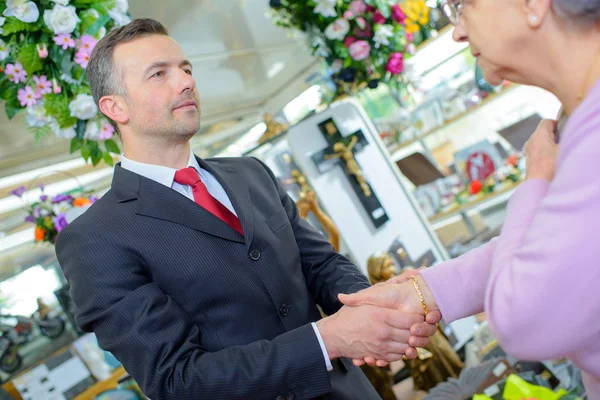 Begrafenisondernemer schudden handen met oudere vrouw — Stockfoto