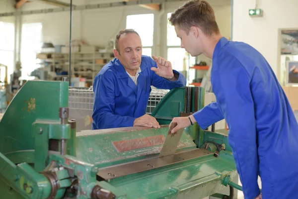 Ingenieur in gesprek met de leerling over machine — Stockfoto