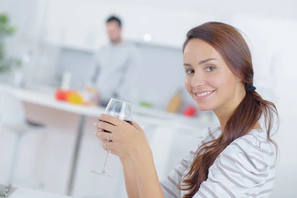 Dame trinkt Glas Wein, Mann kocht — Stockfoto