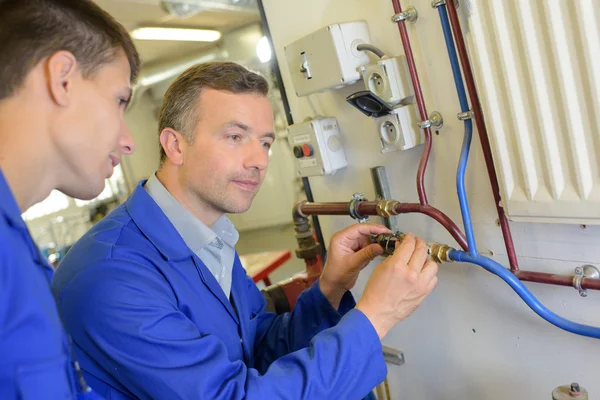 Stajyer radyatör bağlanmak için öğretim tesisatçı — Stok fotoğraf