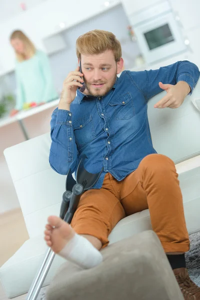 Homem ao telefone, pé enfaixado — Fotografia de Stock