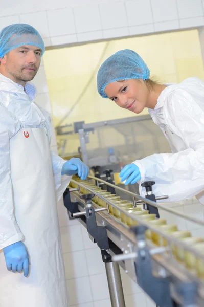 Man och kvinna som arbetar på fabrik produktionslinje — Stockfoto