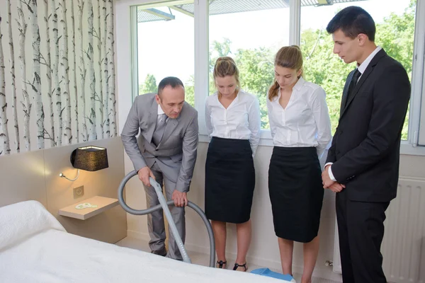 Man toont maids hoe te vacuüm — Stockfoto