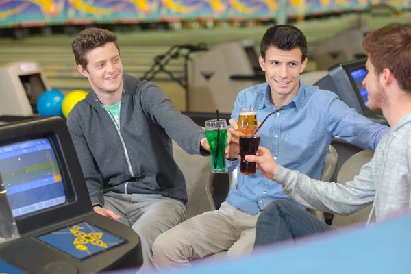 Hombres con bebidas en el centro de bolos — Foto de Stock