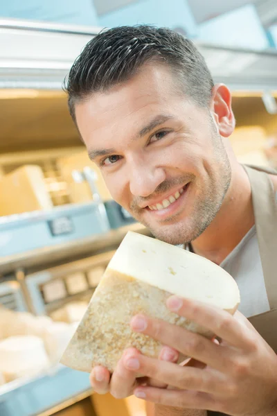 Чоловік тримає шматочок сиру — стокове фото