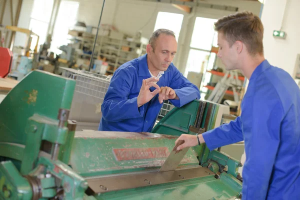 Stagiair met behulp van de machine, superviser die zijn werk goed te keuren — Stockfoto