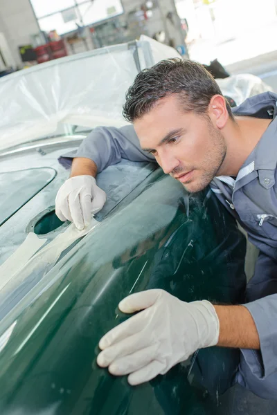 Mechanic assessing wing of classic car — Stock Photo, Image